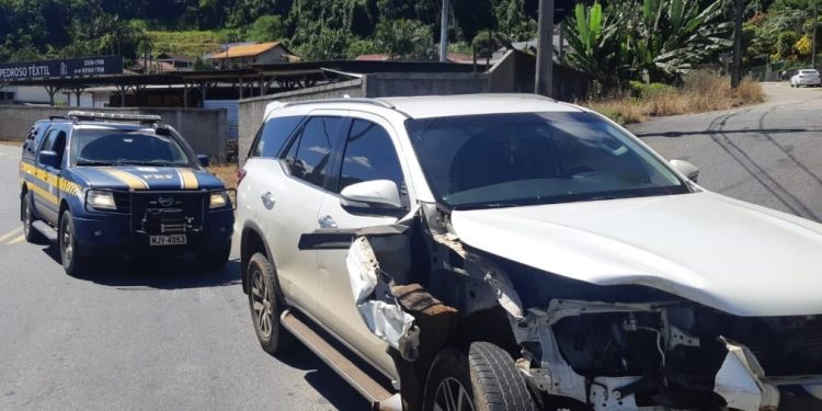 Procurado pela Justiça foge de abordagem, provoca acidentes e é preso com carro roubado, arma e celulares na BR-470 em Blumenau