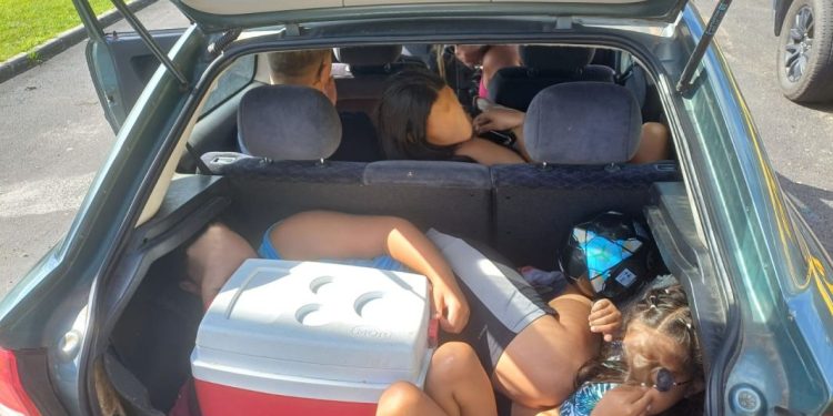 Entre sacolas e uma caixa térmica, crianças eram transportadas em porta-malas de carro parado pela PRF